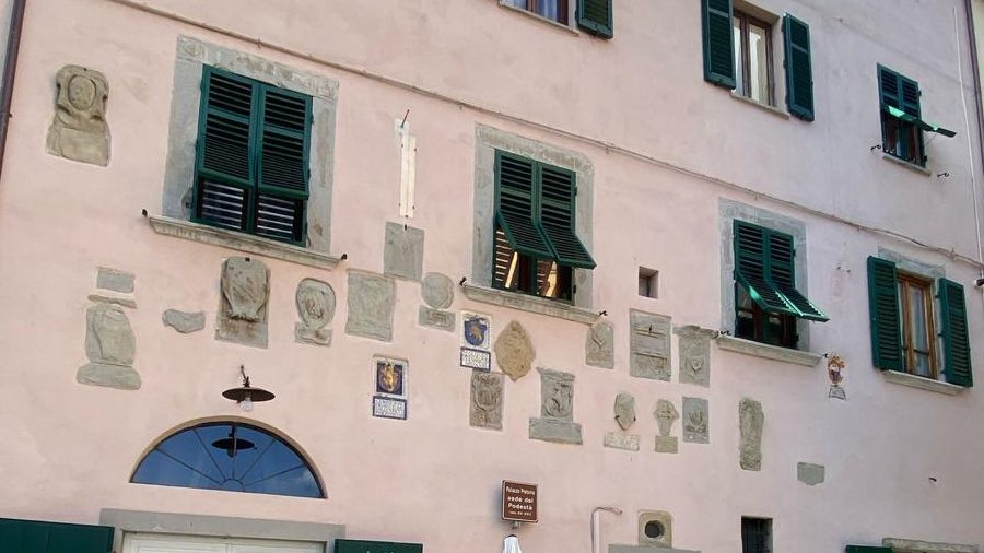 Stemmi in pietra e in terracotta invetriata sulla facciata del Palazzo Podestarile, con la meridiana